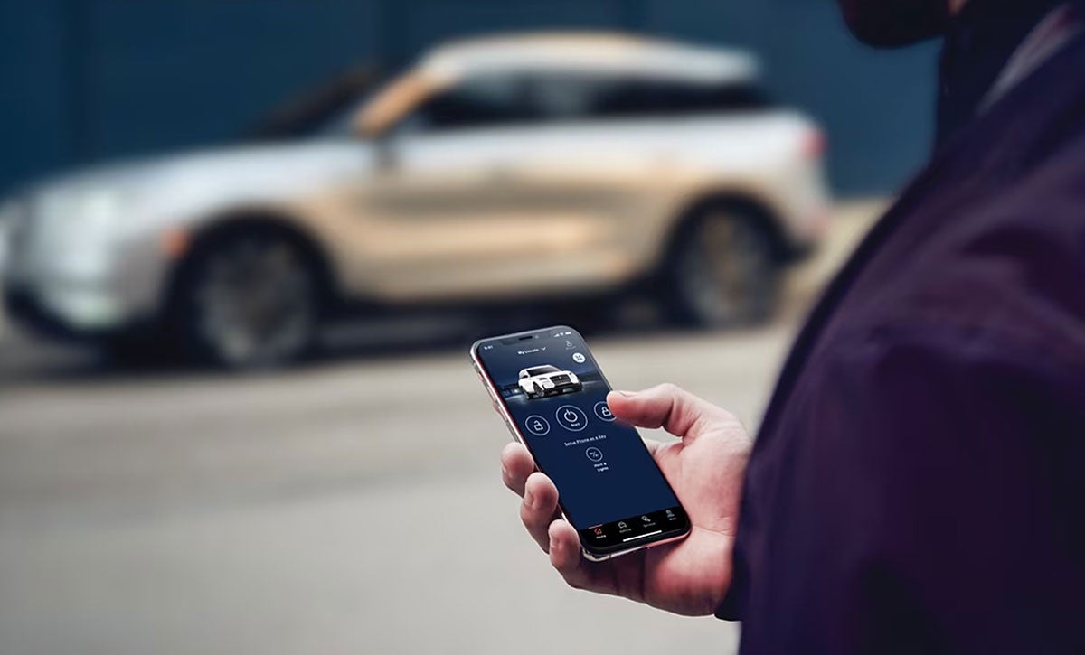 A person using car control app with SUV in background
