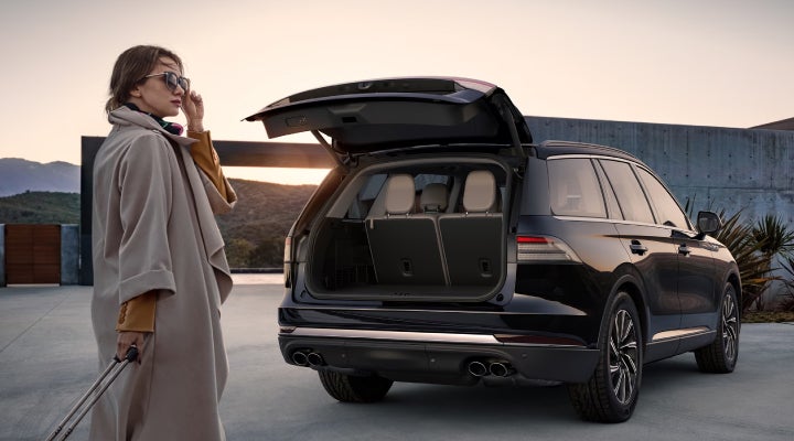 A woman approaches a 2026 Lincoln Aviator® SUV with its rear liftgate open. | Crest Lincoln in Sterling Heights MI