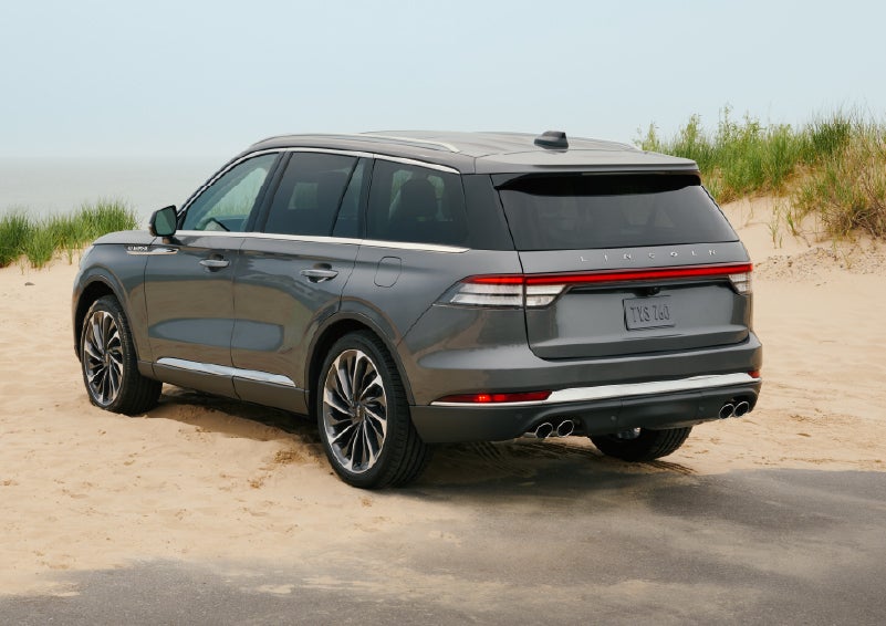 A 2027 Lincoln Aviator® SUV is parked next to sand dunes. | Crest Lincoln in Sterling Heights MI