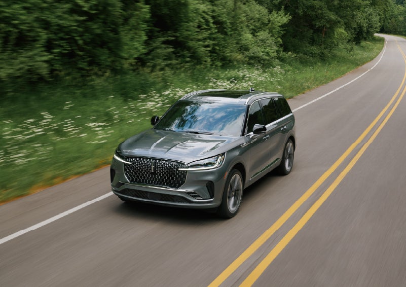 A 2027 Lincoln Aviator® SUV is being driven down a road. | Crest Lincoln in Sterling Heights MI