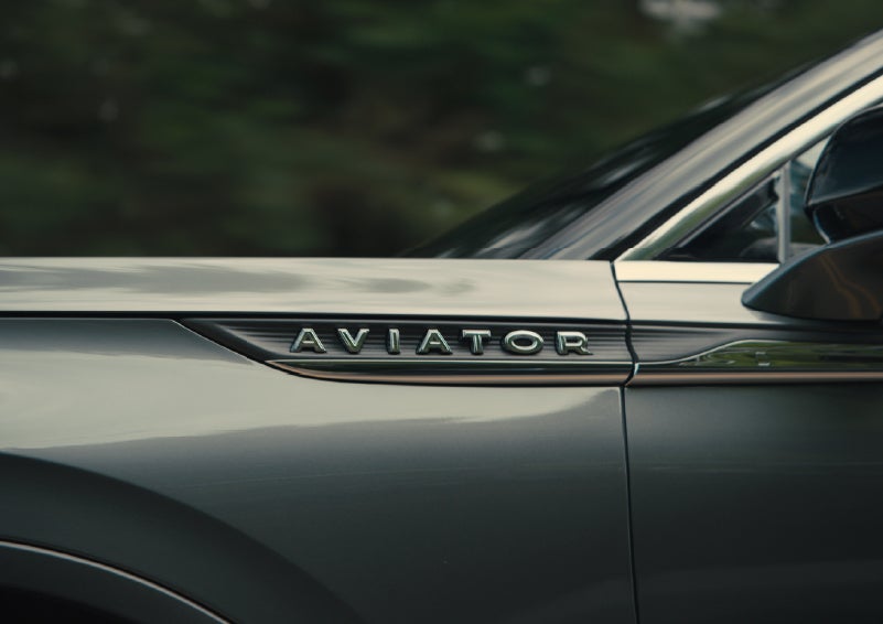 The driver’s side door and fender badging of a gray 2027 Lincoln Aviator® SUV are showcased. | Crest Lincoln in Sterling Heights MI