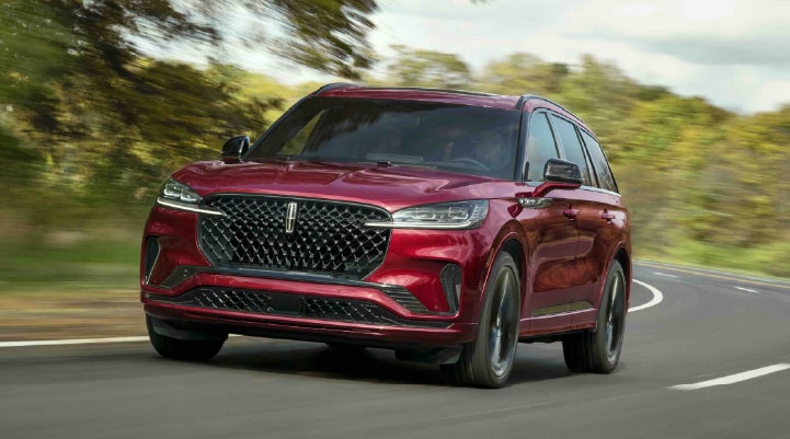 A 2027 Lincoln Aviator® SUV is being driven on a country road | Crest Lincoln in Sterling Heights MI