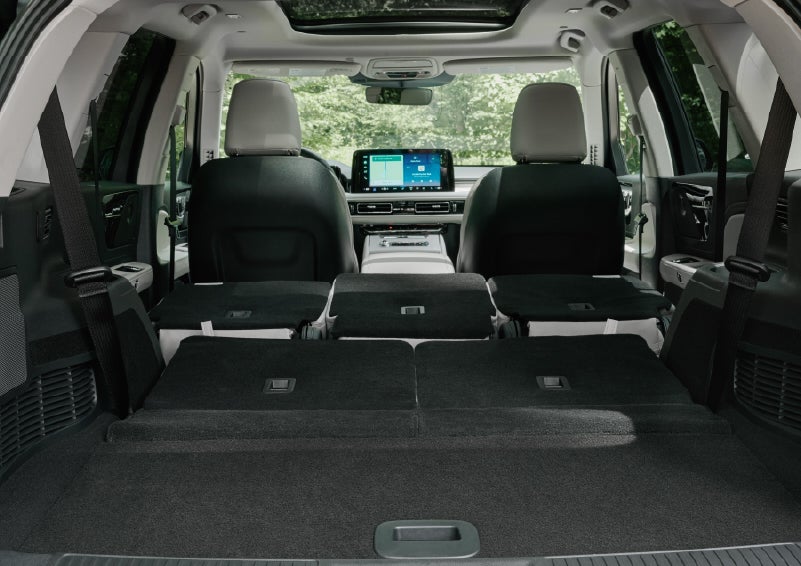 A rear to front view of the interior of a 2027 Lincoln Aviator® Black Label™ SUV shows the third and second rows folded flat | Crest Lincoln in Sterling Heights MI