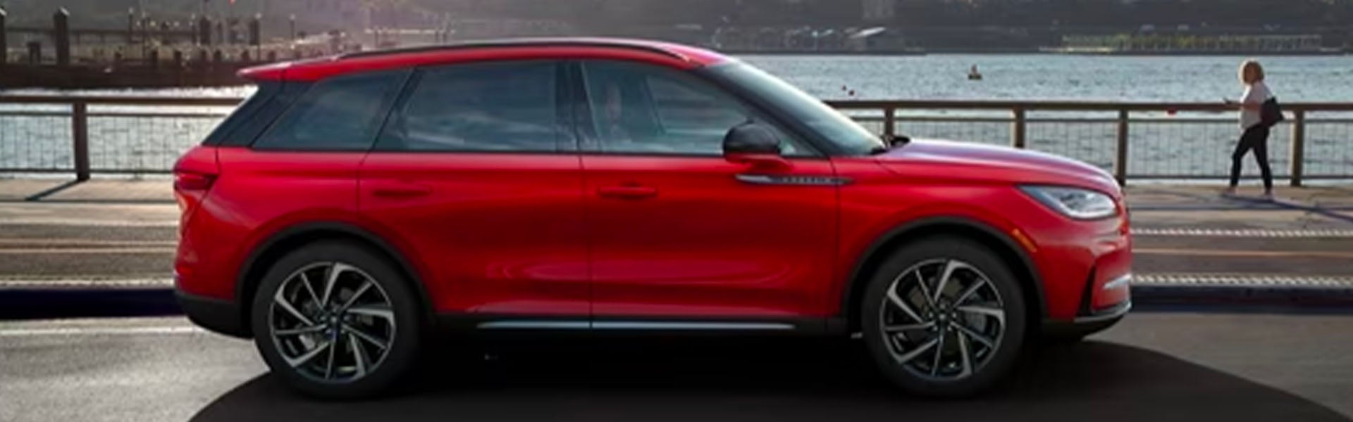 Red Lincoln Corsair SUV parked on a bridge railing.