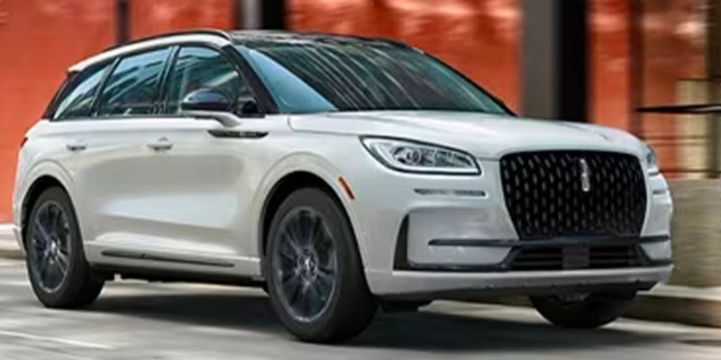 White Lincoln Corsair SUV driving in a city street