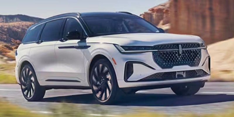 White modern Lincoln SUV driving on a desert highway