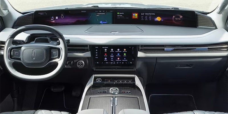 Driver's hand touching the center console screen inside a car