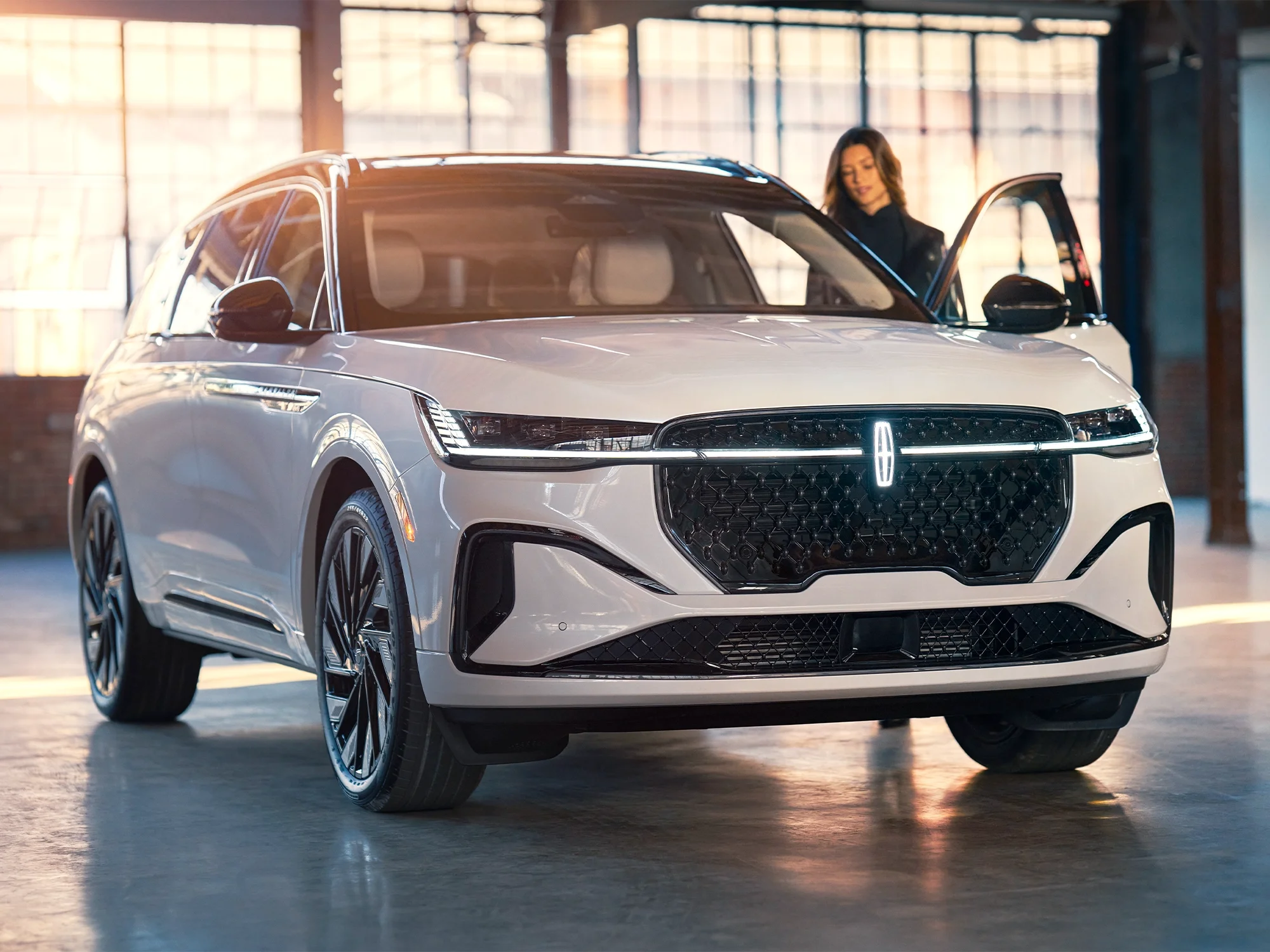 A white Lincoln SUV with lady