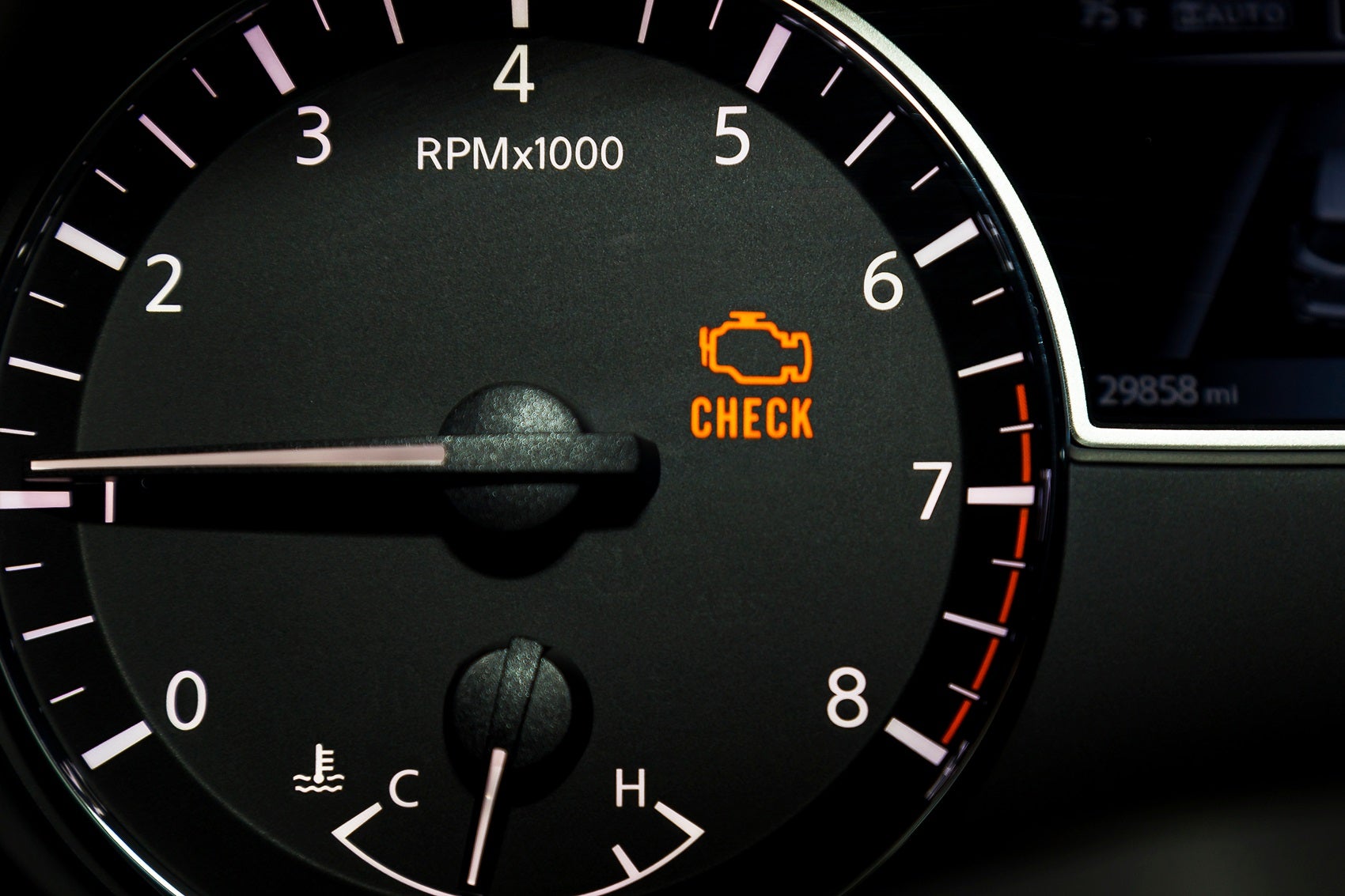 An orange check engine light appearing inside a Lincoln