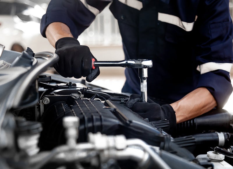A person installing parts into car